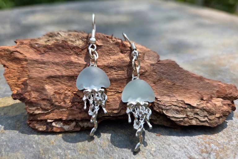 Red rhinestone heart attached to a gold-tone keyring, with the addition of a red pom-pom a gold tone shell a red and white fish charm